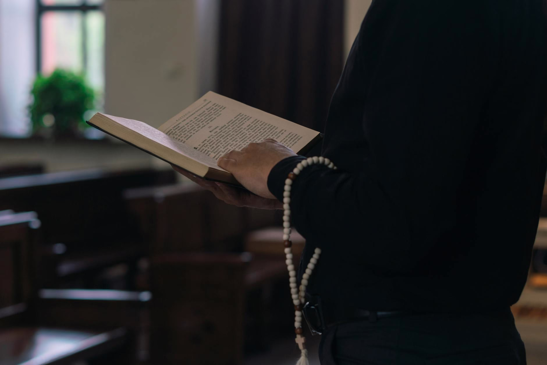 a person in black long sleeves holding a bible